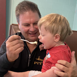 A proud Fire n Ice patron serves grand kid a scoop of ice cream.