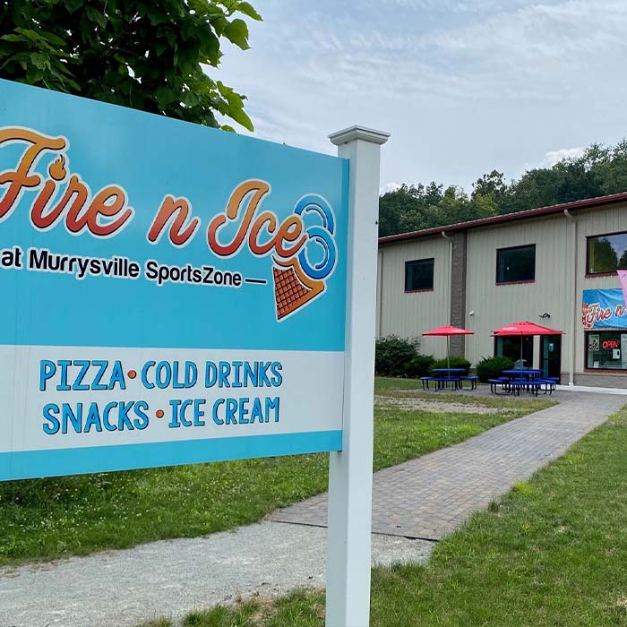 Large Fire n Ice pizza snack shop and ice cream shop sign in front of WHT trail path.